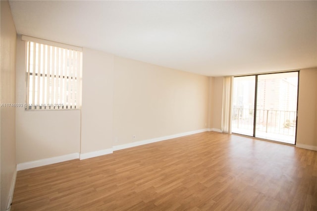 empty room featuring hardwood / wood-style floors and floor to ceiling windows