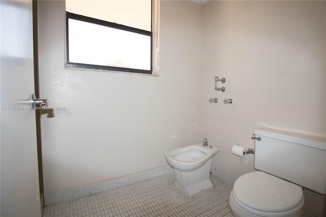 bathroom featuring a bidet, toilet, and tile patterned floors