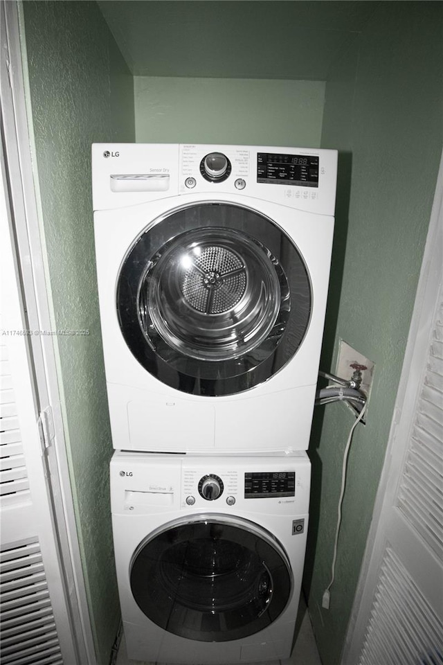 laundry area featuring stacked washing maching and dryer