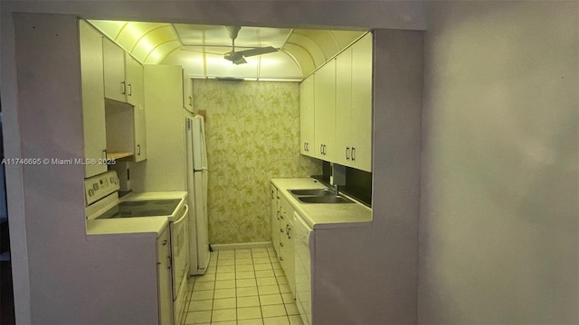 kitchen featuring electric range, white cabinetry, sink, and light tile patterned floors