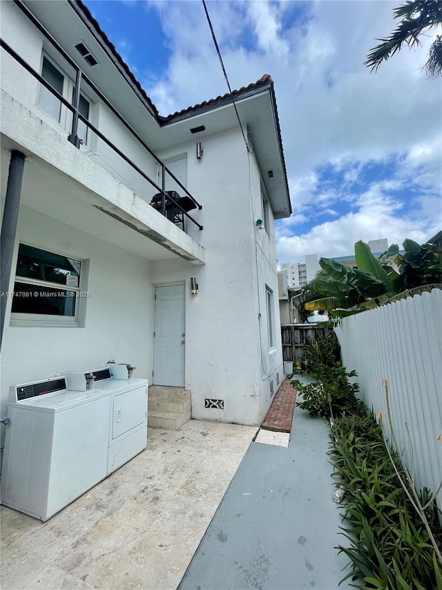 view of home's exterior featuring independent washer and dryer and a patio area