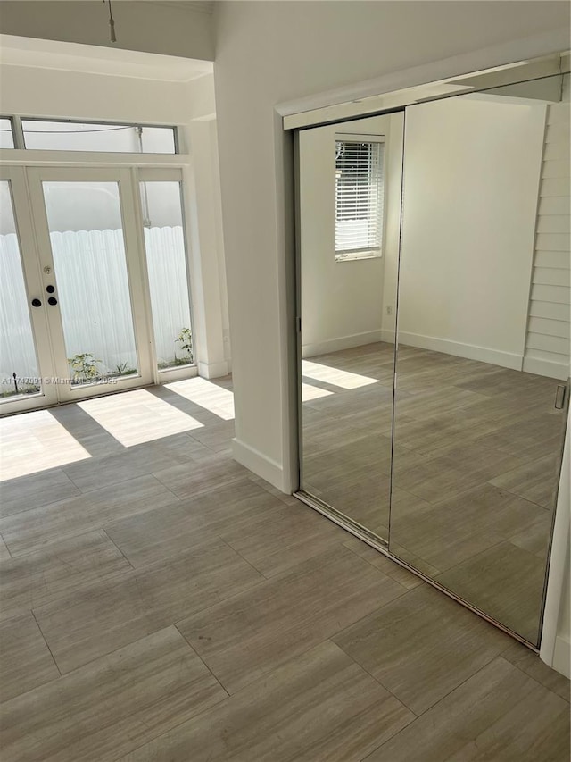 unfurnished bedroom with french doors, a closet, and light hardwood / wood-style floors