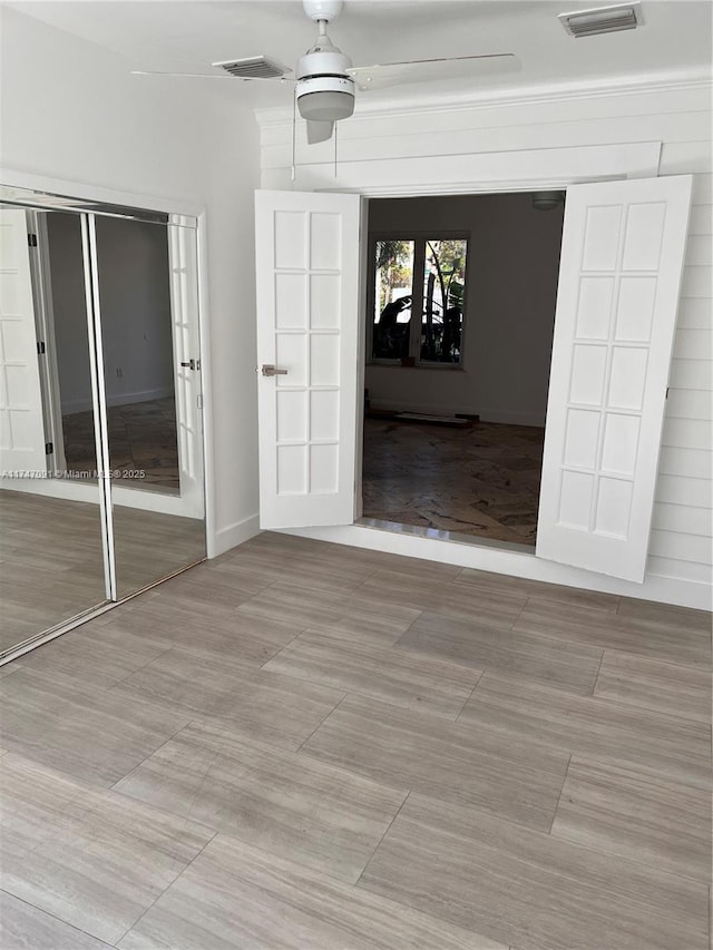 interior space with ceiling fan and french doors