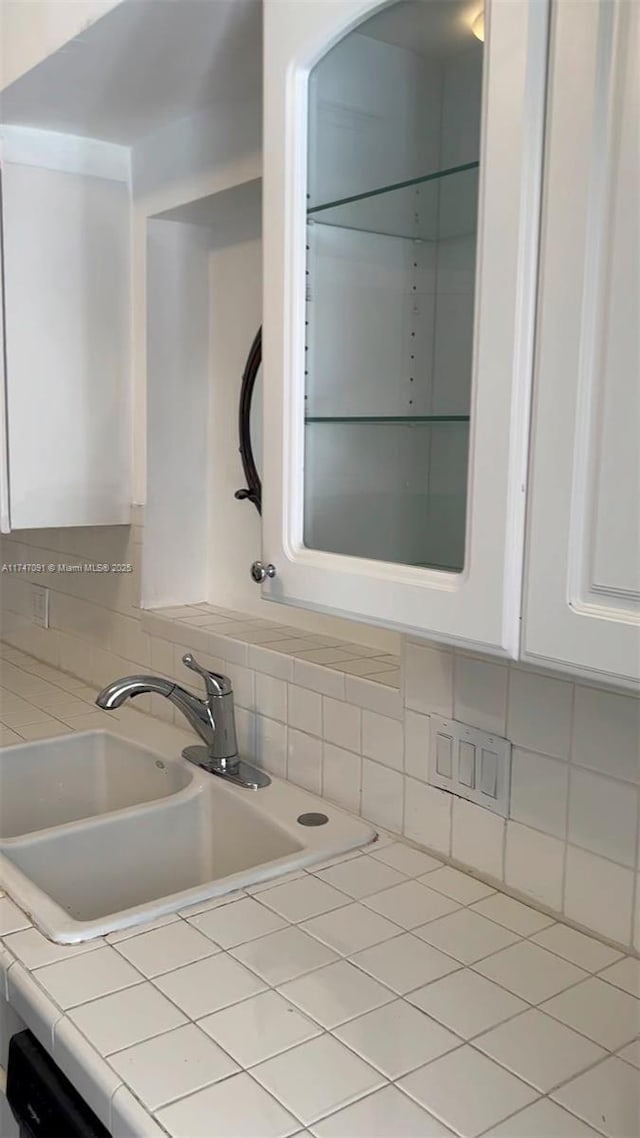 kitchen featuring white cabinets, sink, tile countertops, and tasteful backsplash