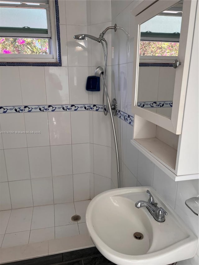 bathroom featuring sink and a tile shower