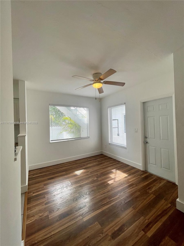 empty room with ceiling fan and dark hardwood / wood-style floors