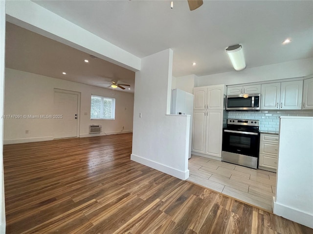 kitchen featuring ceiling fan, white cabinetry, stainless steel appliances, and tasteful backsplash