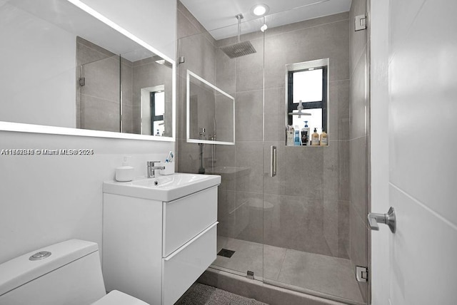 bathroom featuring vanity, an enclosed shower, and toilet