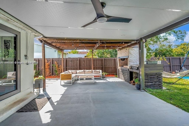 view of patio / terrace with ceiling fan and an outdoor living space with a fireplace