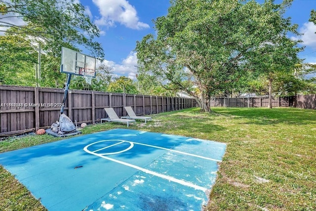 view of sport court with a lawn