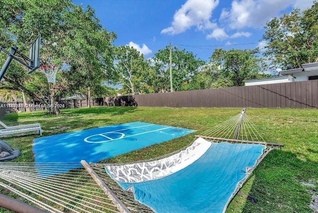 view of basketball court featuring a yard