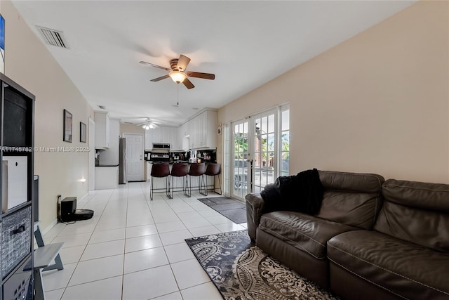living room featuring a ceiling fan, french doors, visible vents, and light tile patterned floors