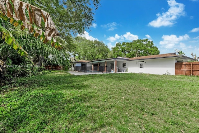 back of house featuring a patio area, a lawn, and fence