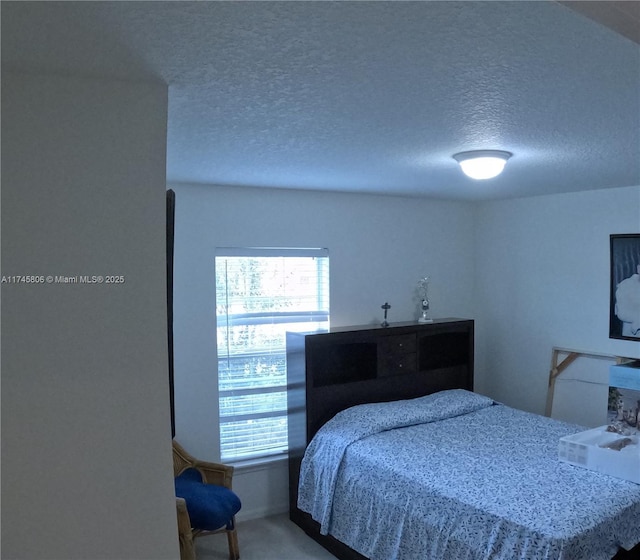 bedroom featuring a textured ceiling and carpet floors