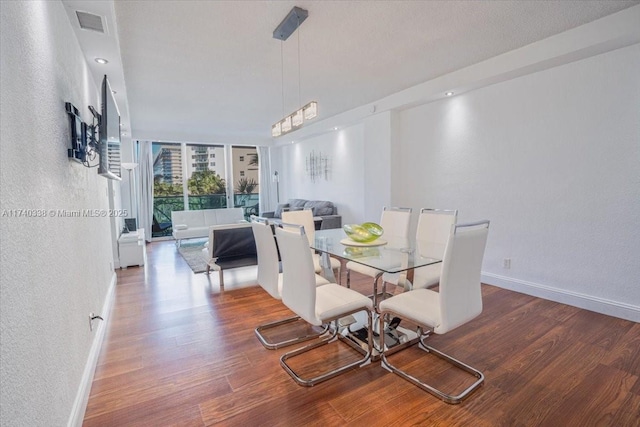 dining space featuring a wall of windows and hardwood / wood-style flooring