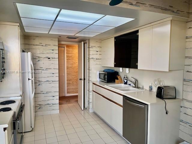 kitchen featuring white cabinetry, sink, stainless steel appliances, and light tile patterned floors