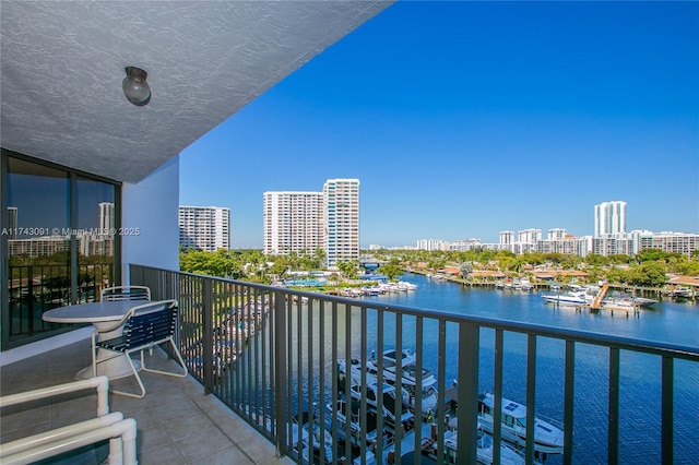 balcony featuring a water view and a city view