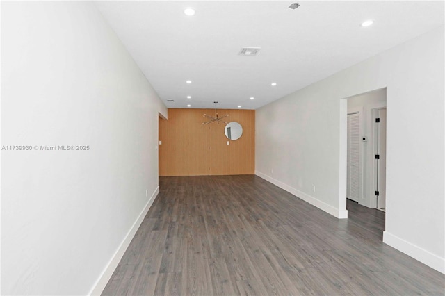 spare room featuring baseboards, dark wood finished floors, visible vents, and recessed lighting