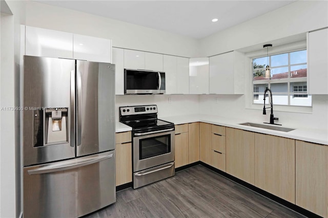 kitchen featuring modern cabinets, appliances with stainless steel finishes, light countertops, and a sink