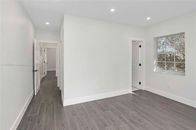 spare room featuring baseboards, dark wood-type flooring, and recessed lighting