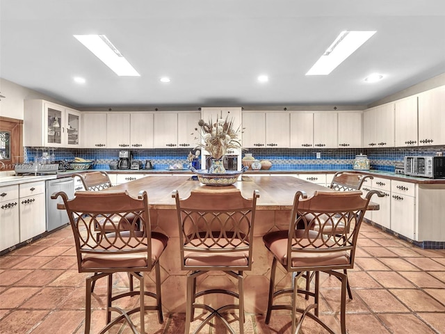 6200 SW 112th St, Pinecrest, FL 33156 - kitchen featuring stainless steel dishwasher, decorative backsplash, a kitchen island, a breakfast bar, and recessed lighting