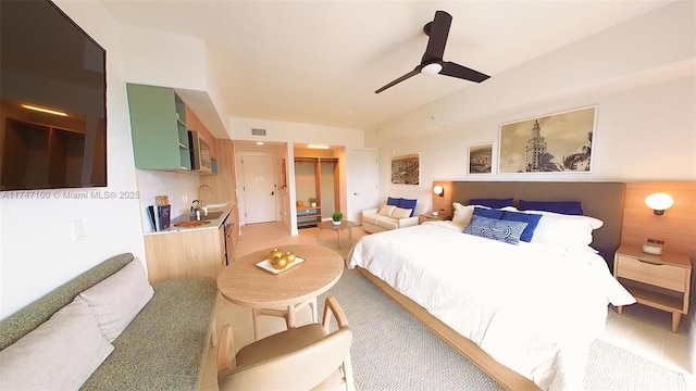 bedroom featuring ceiling fan, sink, vaulted ceiling, and a closet