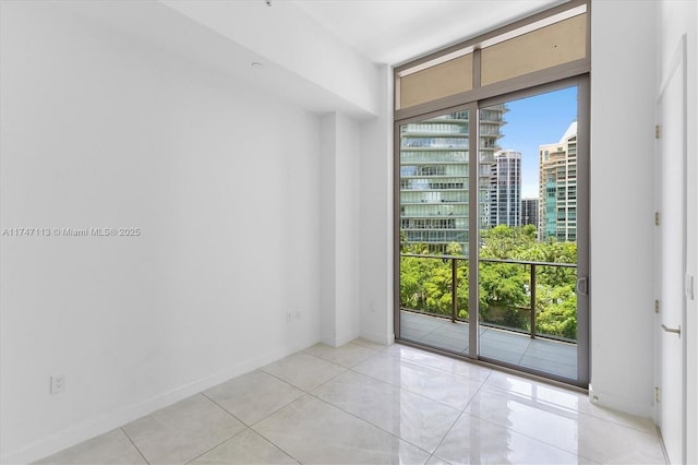 tiled empty room featuring floor to ceiling windows