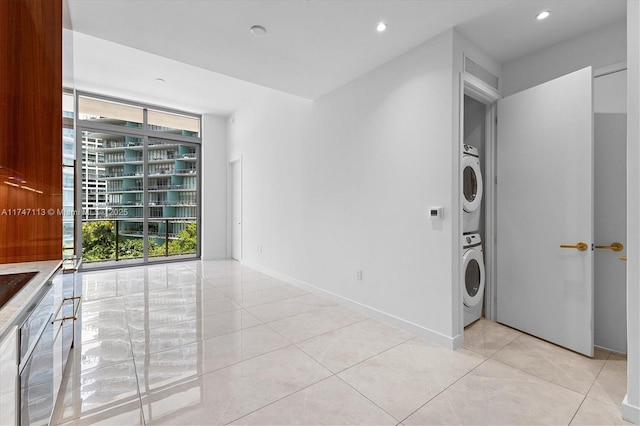 interior space with stacked washer / dryer and light tile patterned floors