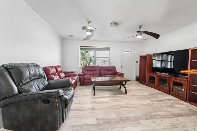 living room with light wood finished floors, visible vents, crown molding, and ceiling fan
