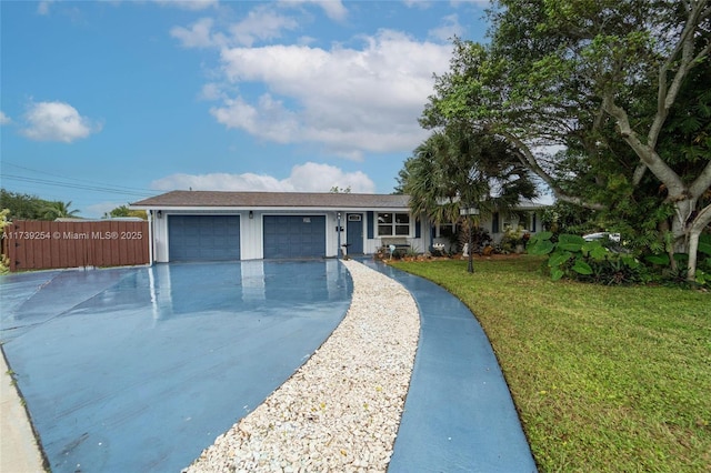 ranch-style home featuring driveway, fence, an attached garage, and a front lawn