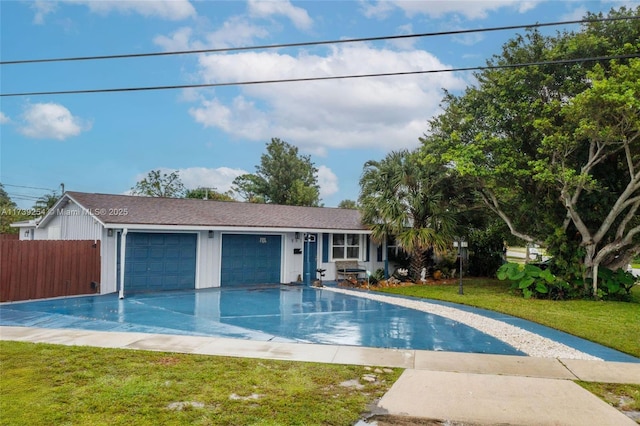 view of swimming pool with fence and a lawn