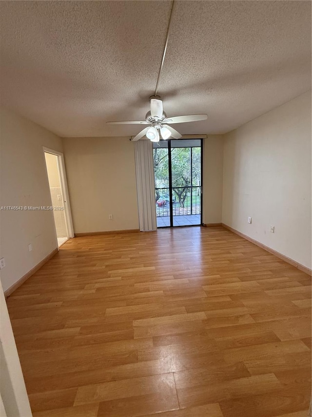 empty room with baseboards, ceiling fan, and light wood finished floors