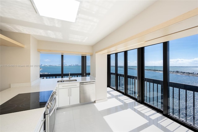 kitchen featuring white cabinetry, sink, a water view, and stainless steel appliances