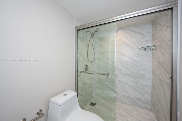 bathroom featuring toilet and a shower with shower door