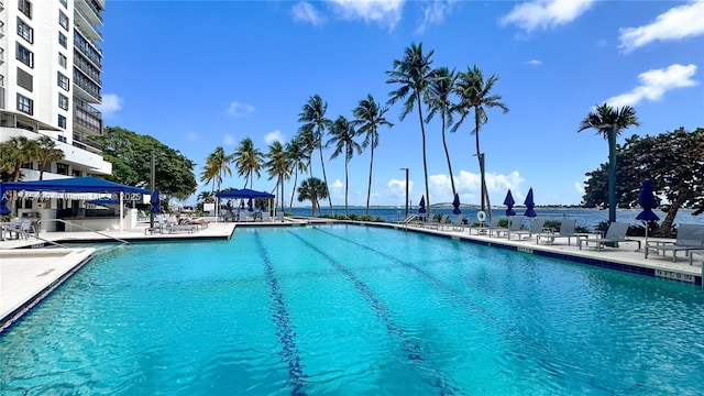 view of swimming pool with a patio, a water view, and a gazebo