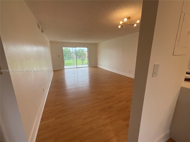 unfurnished room with hardwood / wood-style floors and a textured ceiling