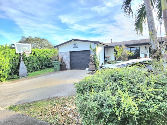 view of front of home with concrete driveway, an attached garage, and stucco siding