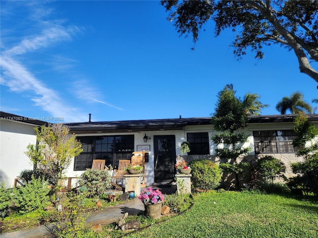 single story home with a front lawn and stucco siding