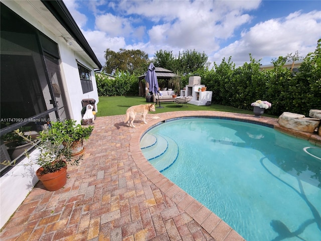 view of swimming pool featuring a fireplace, a patio, and a gazebo