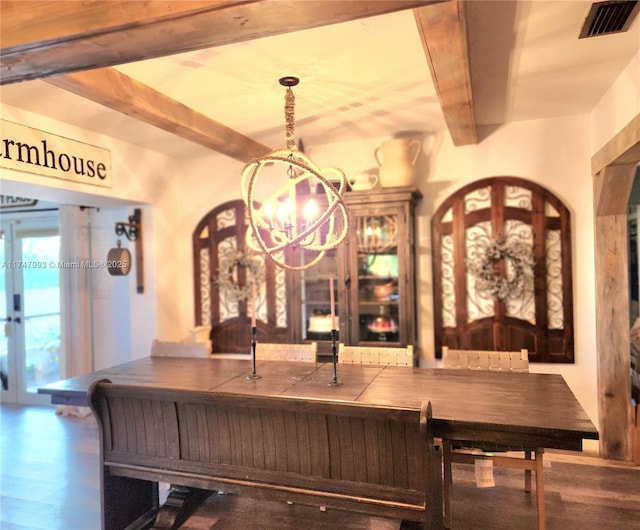 dining room with beamed ceiling, a chandelier, and hardwood / wood-style floors