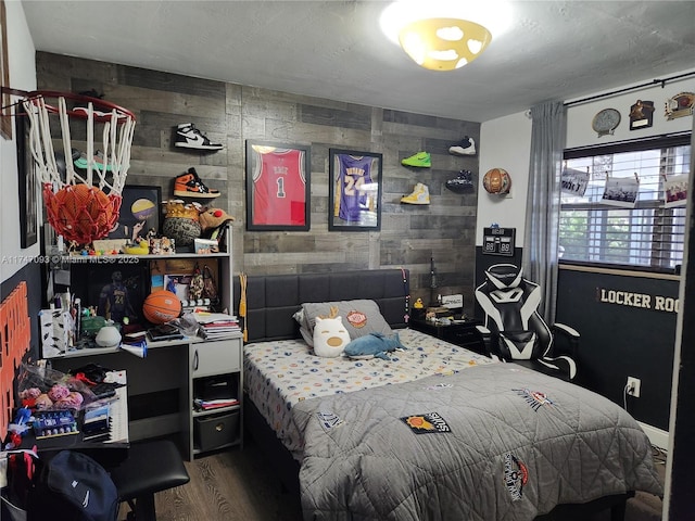 bedroom featuring wooden walls and hardwood / wood-style floors