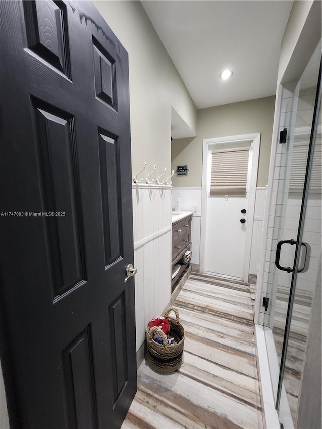 interior space featuring hardwood / wood-style floors, vanity, and walk in shower