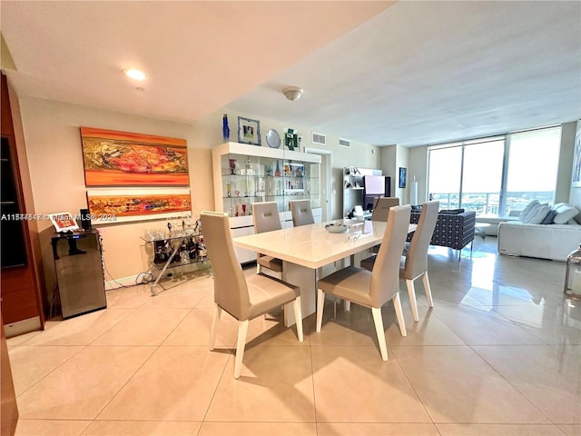 tiled dining space featuring a wall of windows