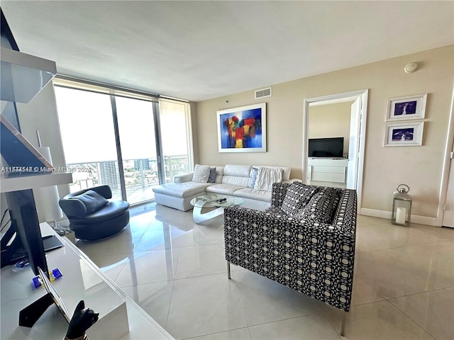 living room featuring a wall of windows and light tile patterned flooring