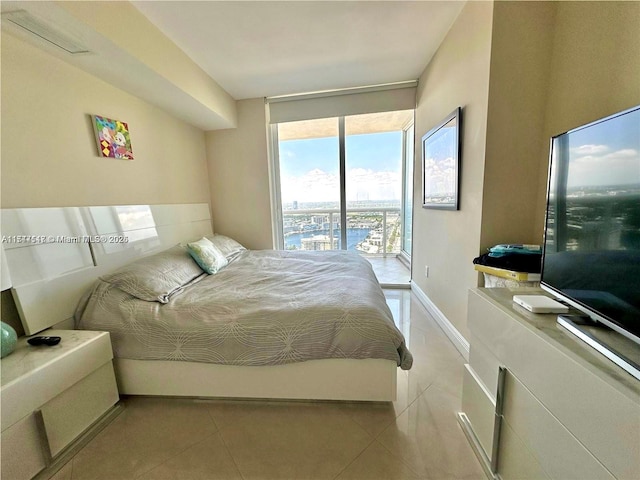 bedroom featuring access to exterior, floor to ceiling windows, and light tile patterned floors