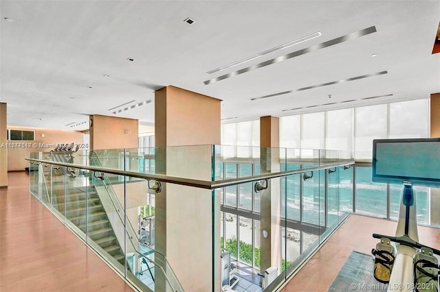 corridor with a wall of windows and light hardwood / wood-style floors