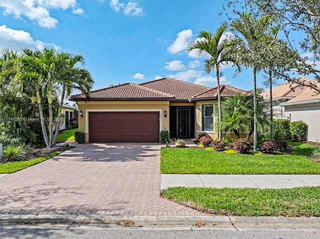 mediterranean / spanish-style house with a front yard and a garage