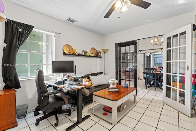 tiled office space featuring ceiling fan with notable chandelier, plenty of natural light, and a textured ceiling