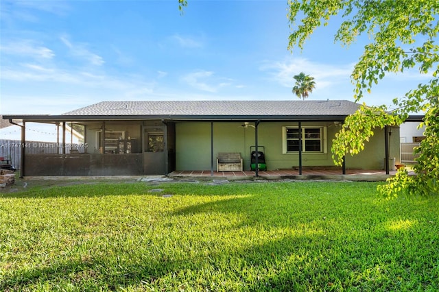 rear view of property with a lawn and a sunroom