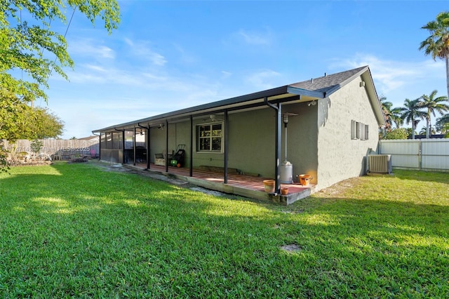 back of property with a lawn, a patio, and central AC